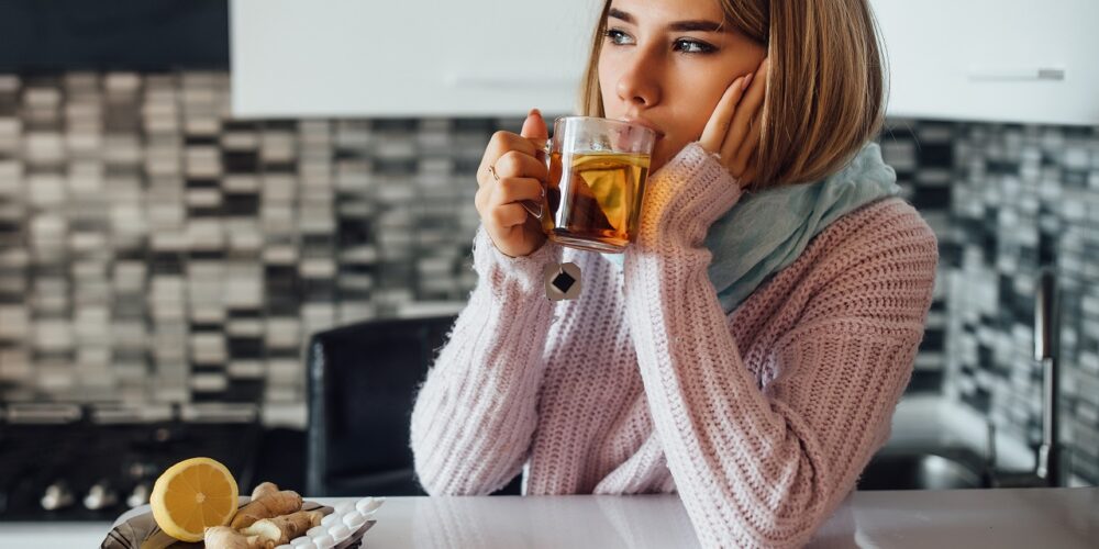 Fotografie: Mladá žena pije čaj s citronem